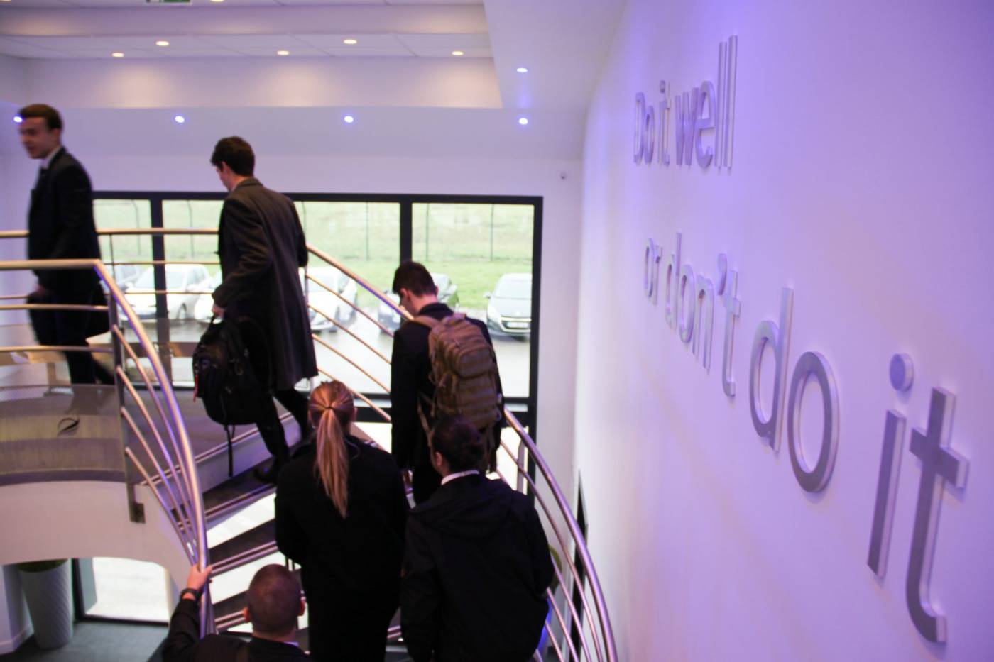 Élèves Astonfly dans le hall du campus, devant le mur « Do it well or don't do it »